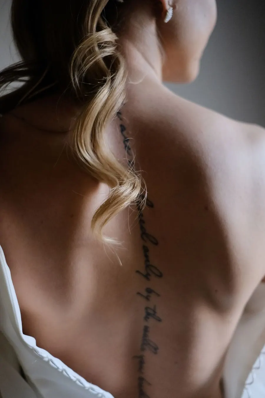 Phrase manuscrite tatouée le long de la colonne vertébrale