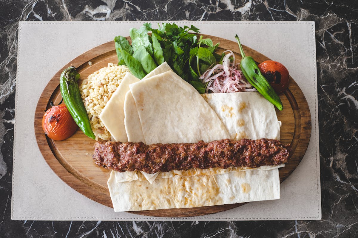 Adana kebab sur plateau bois