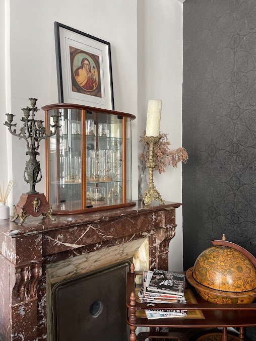 Coin salon de l'atelier Skull & Bones — cheminée en marbre et cabinet de curiosités